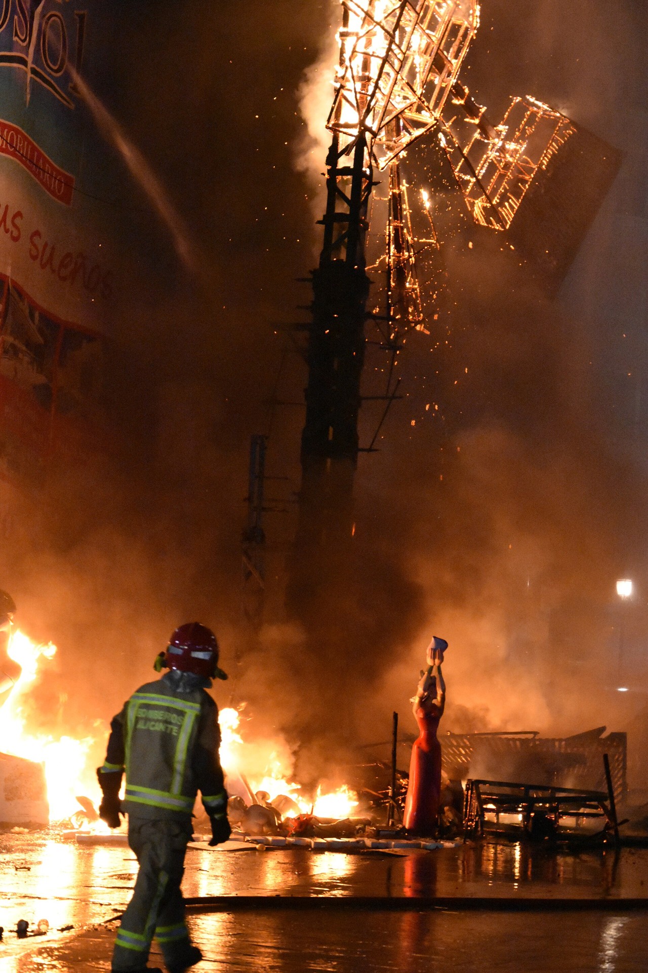 Firefighters beside a burning monument during Alicante’s Hogueras